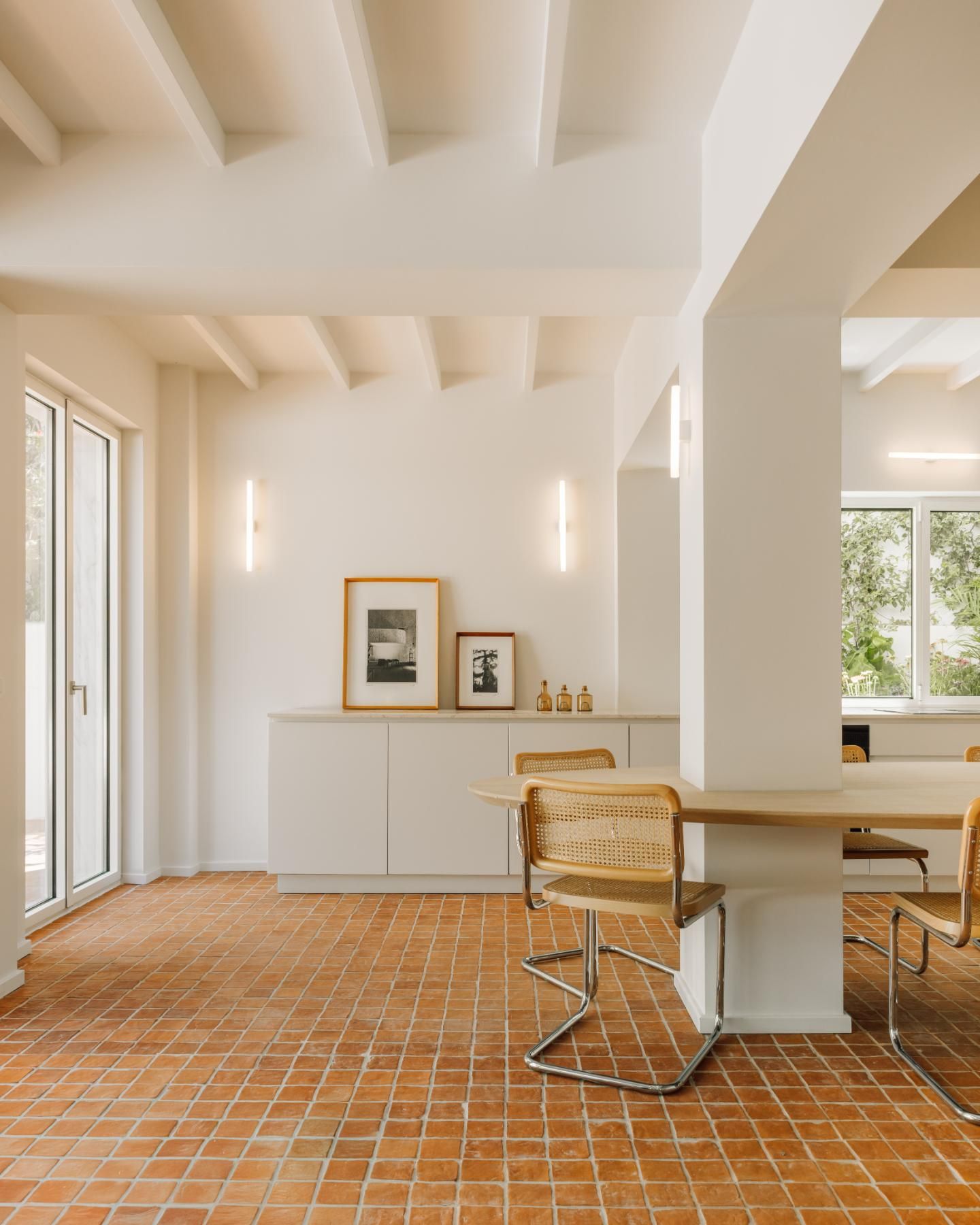 cucina a vista cucina bianca pavimento in cotto tavolo integrato con colonna sedie in tubolare e paglia di vienna